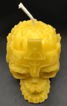 Load image into Gallery viewer, Creepy, ornate skull beeswax candle with cross crown.  Eyes glow after it starts to burn down.  Top view.
