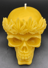 Load image into Gallery viewer, Large, Creepy, gothic skull beeswax candle with leaf crown.  Eyes glow when lit.  Halloween decor or gothic decor.

